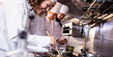 Groupe de chefs préparant des plats dans la cuisine d'un restaurant