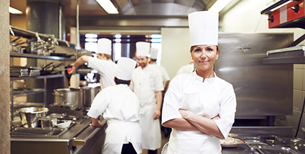 Chef, bras croisés, portrait d'une femme en cuisine